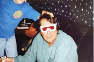 FL Decker wearing paper red goggles facing the camera while I'm holding his head